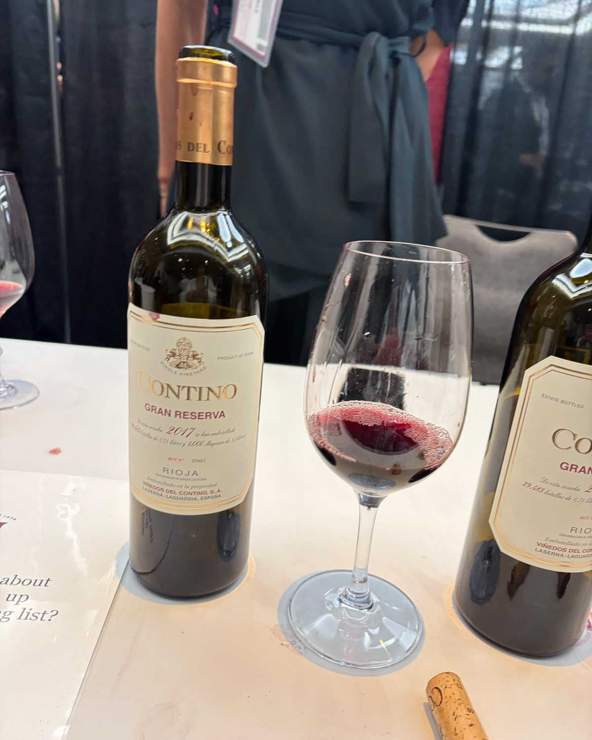 A bottle of Contino Rioja Gran Reserva beside a glass of red wine on a tasting table