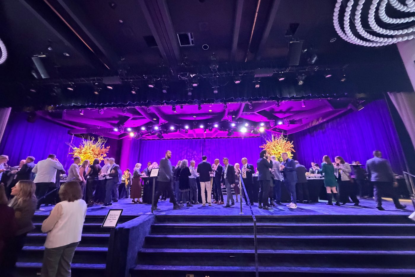 The ballroom stage bathed in purple light with guests gathered below